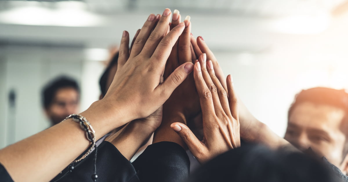 Equipo de trabajo chocando sus manos todos juntos