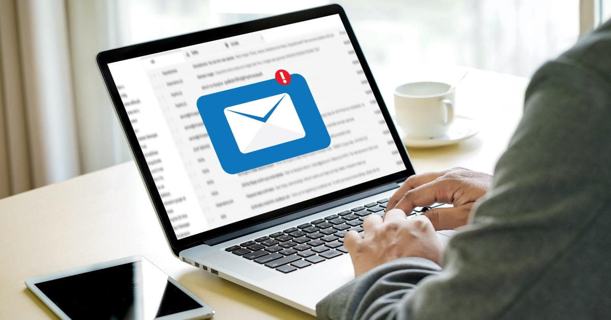 Persona frente a un ordenador en el que se ve la notificación de que ha llegado un mail nuevo