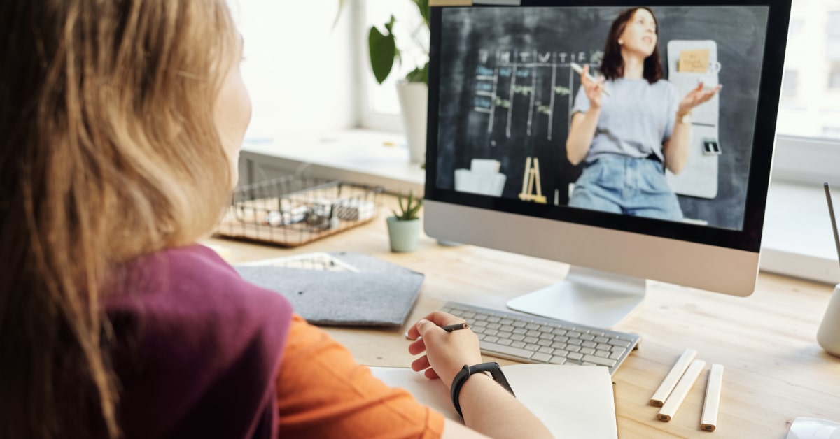 Alumna asistiendo a una clase de formación online en la que la docente está dando un contenido interactivo y participativo