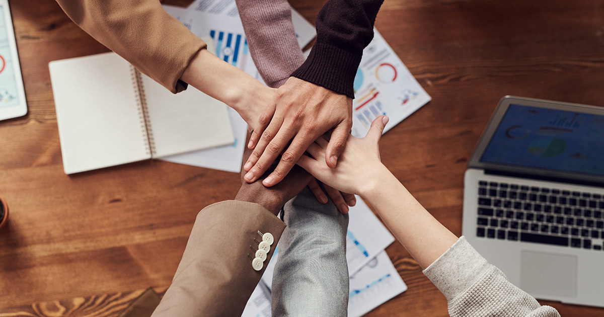 Equipo de trabajo juntando sus manos 