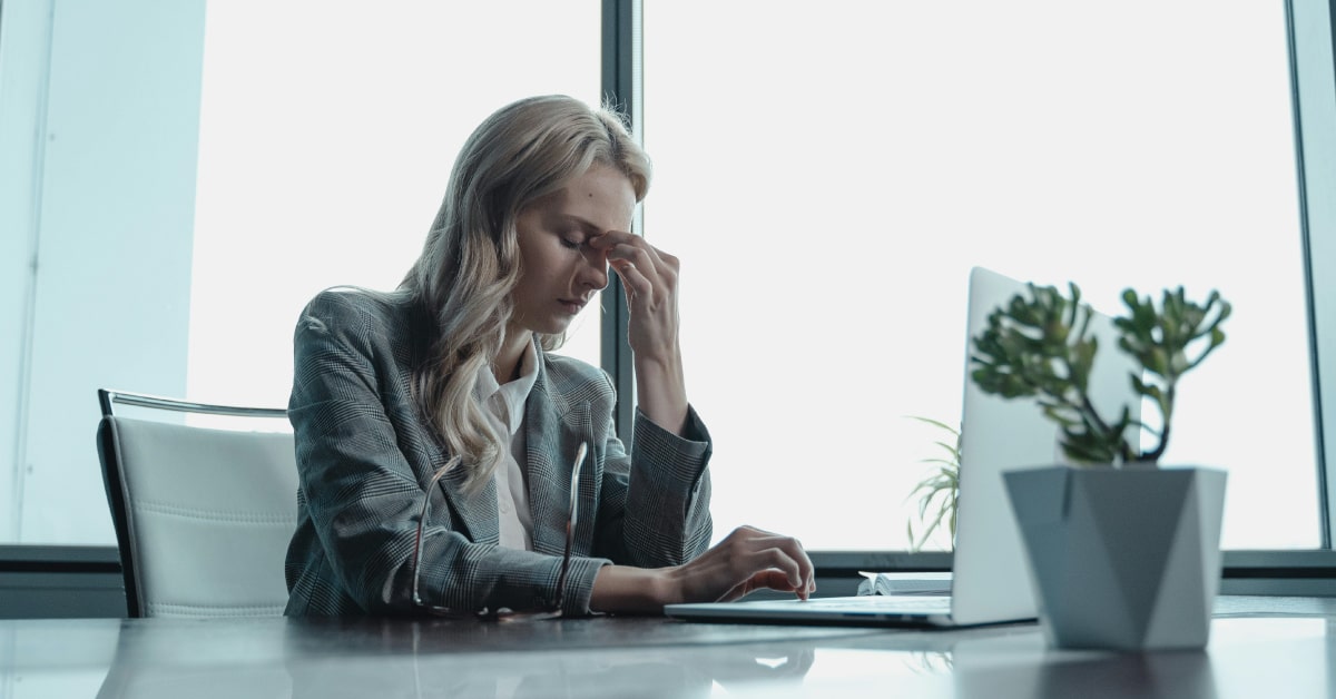 Mujer estresada frente a su ordenador por los peligros de las redes sociales para su marca